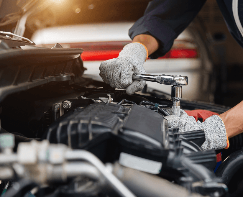Mechanic using a ratchet on an open engine bay